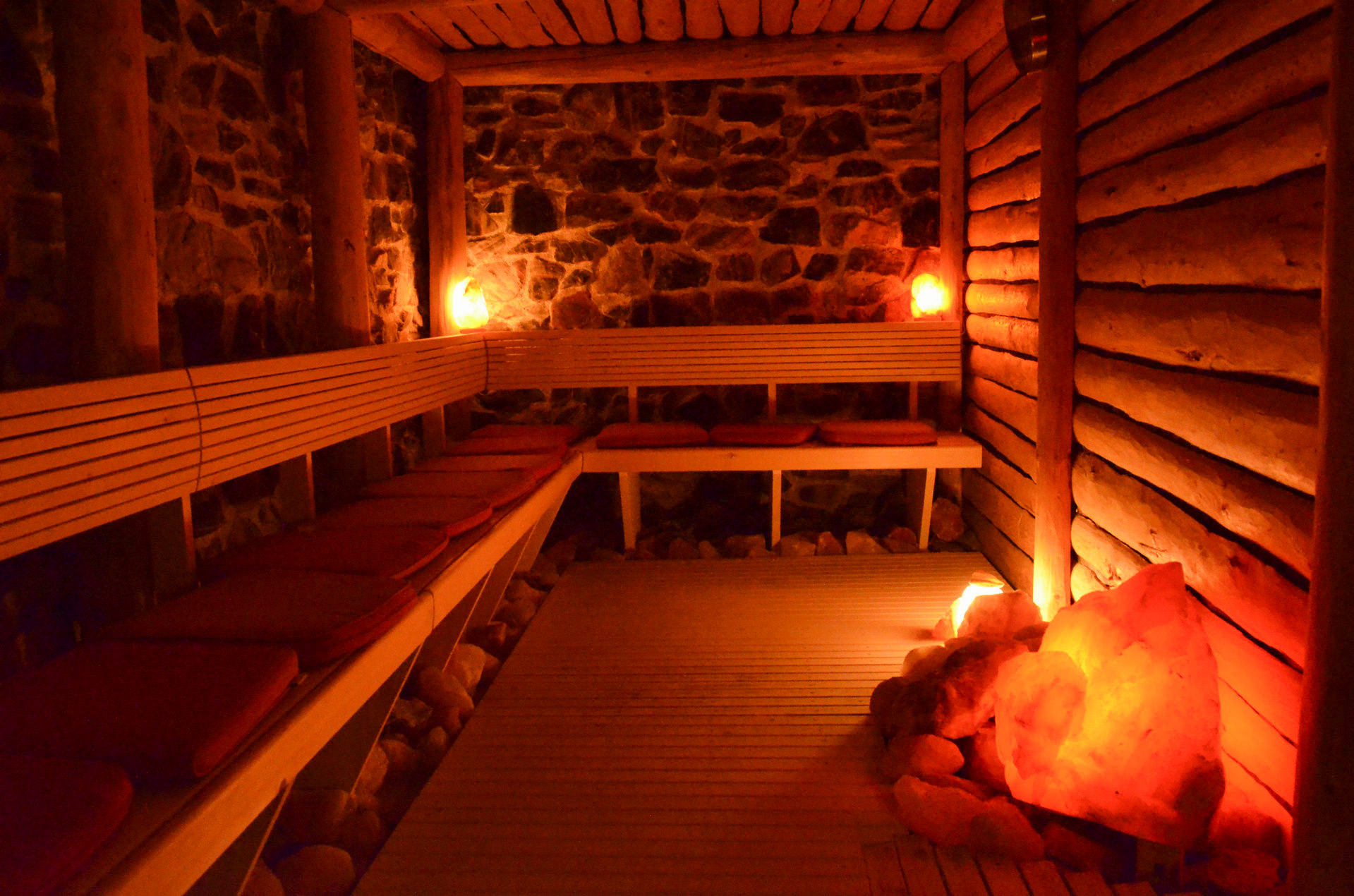 Stimmungsvoll beleuchtete Sauna mit Natursteinwand und leuchtenden Salzkristallen im Hotel Churfürstenhof