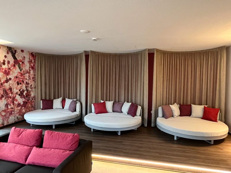 Ruheraum im Spa des Hotel Churfürstenhof mit runden Tagesbetten, bunten Kissen und Vorhängen