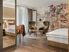 Zimmer Prinzess im Wellnesshotel Churfürstenhof mit floraler Wandgestaltung, grünen Sesseln und großem Spiegel