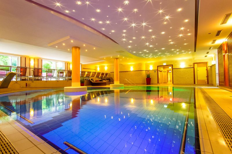 Indoorpool mit beleuchteter Sternenhimmel-Decke und Liegebereich im Hotel Churfürstenhof