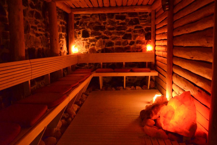 Stimmungsvoll beleuchtete Sauna mit Natursteinwand und leuchtenden Salzkristallen im Hotel Churfürstenhof