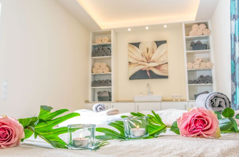 Behandlungsraum im Spa des Hotels Churfürstenhof mit Rosen, Kerzen und gerollten Handtüchern