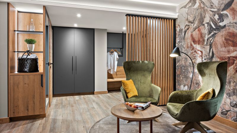 Zimmer Prinzess im Hotel Churfürstenhof Bad Birnbach mit grünen Sesseln, Holzlamellen und Garderobe