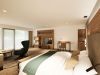 Junior Suite mit Doppelbett, Sessel, Schreibtisch und TV-Wand aus Holz im Hotel Churfürstenhof