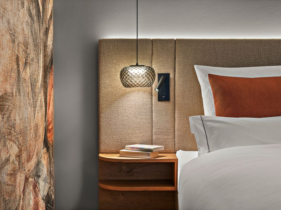 Zimmer Prinzess im Wellnesshotel Churfürstenhof: Bett mit stoffbezogenem Kopfteil, Pendelleuchte und Nachtablage