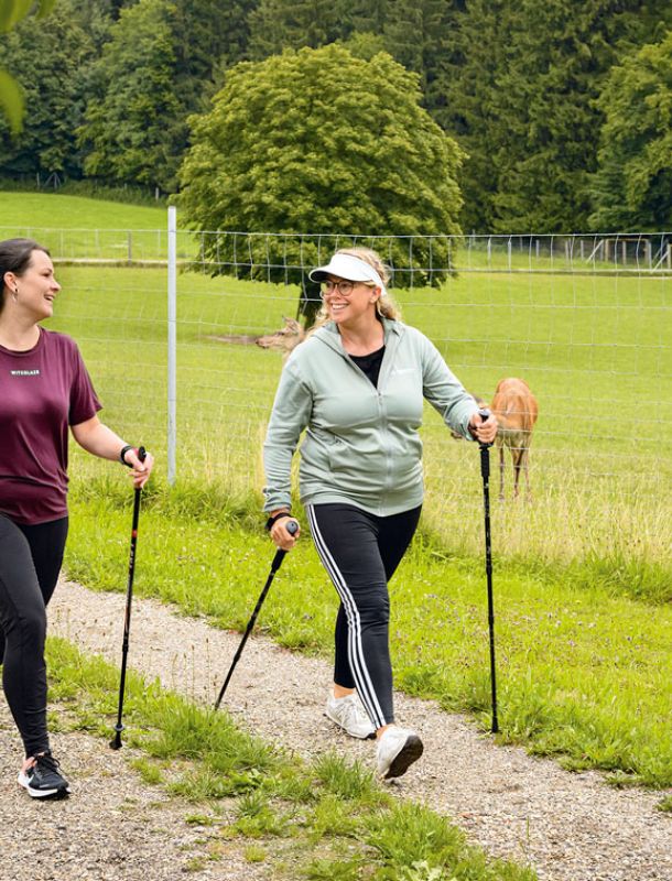 Zwei Frauen beim Nordic Walking am Hirschgehege bei Bad Birnbach, dahinter Hirsche auf der Weide