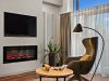 Wohnbereich der Komfort-Suite im Wellnesshotel Churfürstenhof mit Elektrokamin, TV, Sessel und Stehlampe