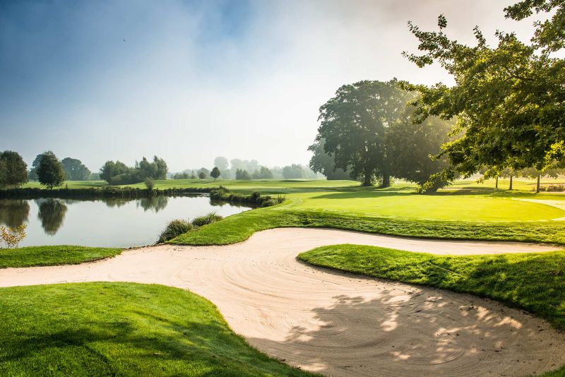 Golfplatz mit Sandbunker und See im Quellness Golf Resort Bad Griesbach im Morgennebel