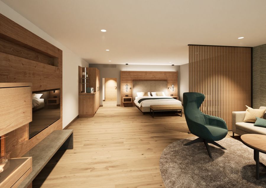 Junior Suite with double bed, green wing chair and light wood panelling at Hotel Churfürstenhof