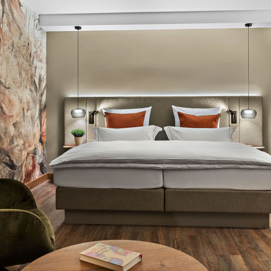 Hotelzimmer Prinzess im Wellnesshotel Churfürstenhof: Doppelbett, grüner Ohrensessel und florales Wandbild
