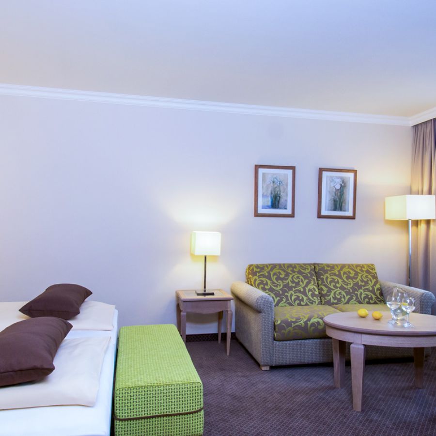 Hotelzimmer Baroness im Churfürstenhof Bad Birnbach mit Doppelbett, Sofa und grünen Farbakzenten